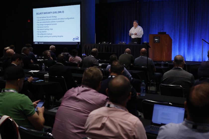 Man on stage giving a lecture to a session